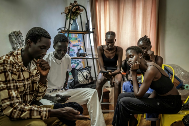Des jeunes mannequins de l'agence Jubalicious regardent des vidéos de défilés lors d'une formation à Juba, le 20 février 2026 au Soudan du Sud