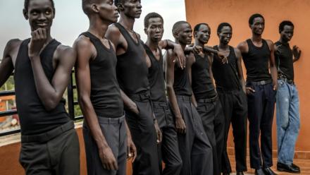 Des jeunes mannequins écoutent les instructions d'un coach pour apprendre à défiler, sur le toit des bureaux de l'agence Jubalicious à Juba, le 20 février 2026 au Soudan du Sud