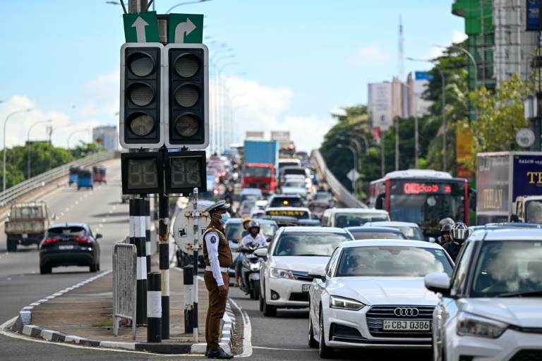 Des automobilistes passent à côté de feux de signalisation éteints, après une panne d’électricité nationale, le 17 octobre 2026 à Colombo, au Sri Lanka