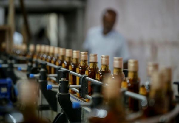 Des bouteilles de whisky Imperial sur une ligne de production à la distillerie Carew and Co. à Darsana, le 23 octobre 2025 dans le sud-ouest du Bangladesh