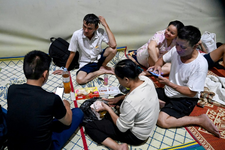 Des habitants abrités dans un gymnase à Vinh, ville côtière de la province de Nghe An, avant l'arrivée du typhon Kajiki, le 25 août 2025 au Vietnam