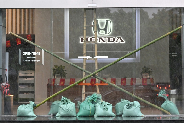 L'entrée d'un concessionnaire automobile renforcée par des sacs de sable et des piquets de bambou à Vinh, ville côtière de la province de Nghe An, avant l'arrivée du typhon Kajiki, le 25 août 2025 au Vietnam