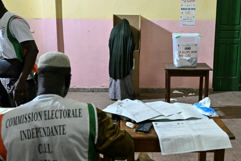 Une personne vote lors des élections législatives en Côte d'Ivoire, sous la surveillance d