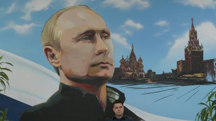 Un panneau mural représentant Vladimir Poutine et la Place rouge, le 20 septembre 2026 dans un bureau de vote de Donetsk, dans les territoires ukrainiens occupés par la Russie

