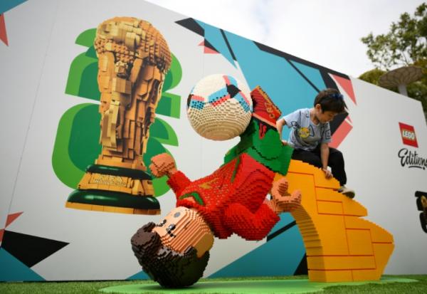 Un enfant escalade un Lego géant représentant le footballeur portugais Cristiano Ronaldo, fait de plus de 30.000 briques à Carlsbad (Etats-Unis), le 13 juin 2026