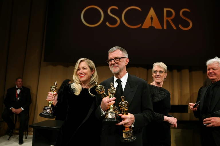 Le réalisateur américain Paul Thomas Anderson et la productrice américaine Sarah Murphy avec les Oscars remportés par le film 