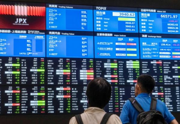 Des panneaux d'affichage électroniques indiquant les cours boursiers et les indicateurs économiques à la Bourse de Tokyo, le 1er juin 2026.