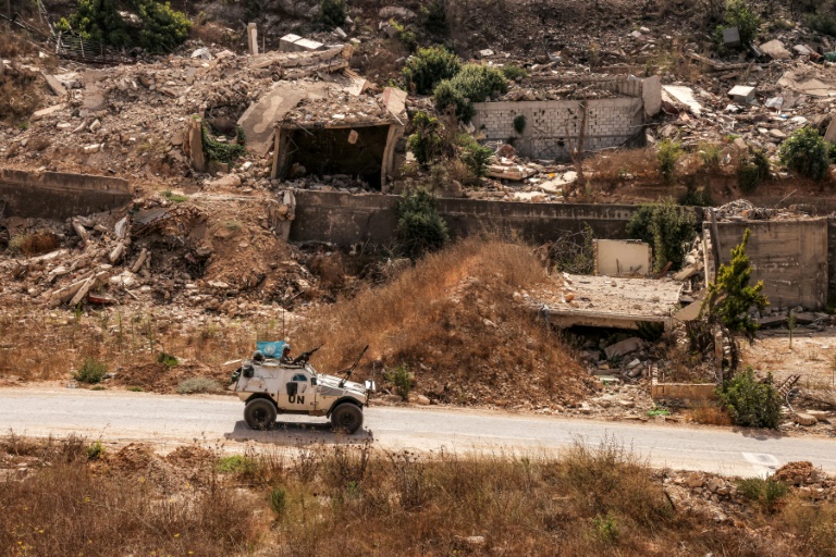 Un véhicule blindé de la Force intérimaire des Nations Unies au Liban (Finul) passe devant des bâtiments détruits le long d'une route dans le village de Kfar Kila, dans le sud du Liban, près de la frontière avec le nord d'Israël, le 27 août 2025