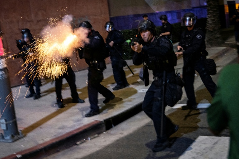 Des policiers de Los Angeles, dont l'un fait feu avec une arme non létale, le 30 janvier 2026 dans la ville californienne lors d'une manifestation contre la police de l'immigration
