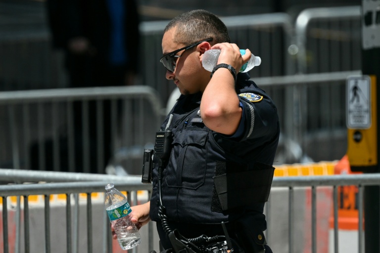Un policier se rafraichit avec une bouteille d'eau lors d'une vague de chaleur le 3 juillet 2026 à New York