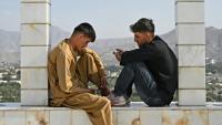 Des jeunes Afghans consultent leurs smartphones, sur la colline de Wazir Akbar Khan, à Kaboul, le 10 août 2026