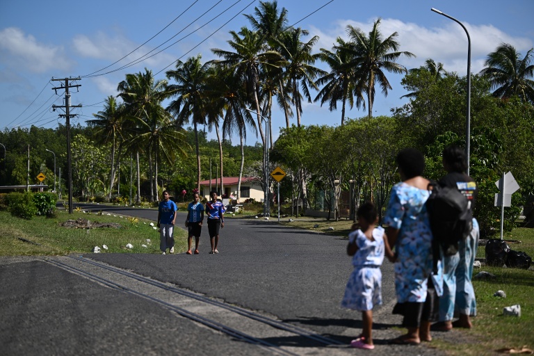 Des habitants marchent sur la route menant au village de Rukurukulevu, aux Fidji, le 9 octobre 2026