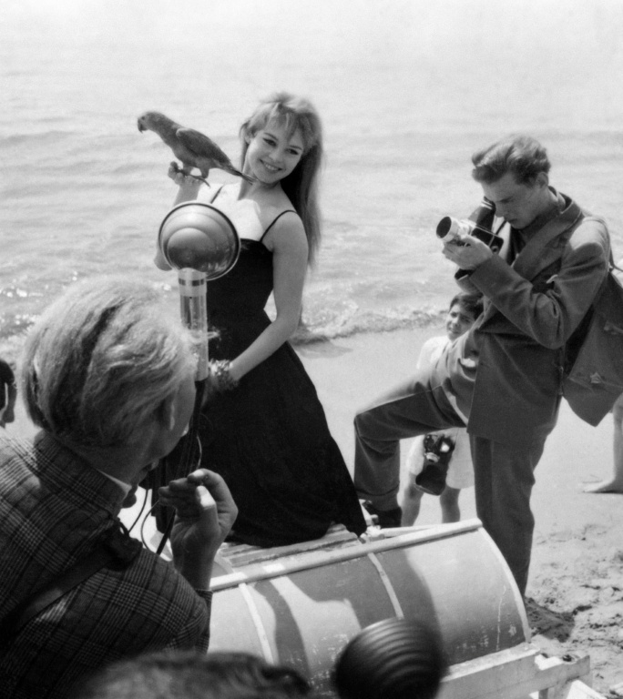 L'actrice française Brigitte Bardot pose avec un perroquet sur la plage en marge du festival de Cannes, le 25 avril 1956 