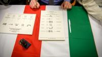 Des bulletins de vote sont placés sur un drapeau hongrois dans un bureau de vote à Budapest, au début des élections législatives en Hongrie, le 12 avril 2026
