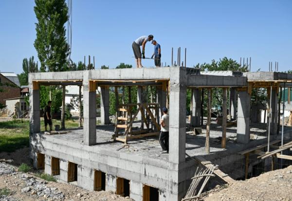 Des ouvriers construisent une bibliothèque, une salle de conférence et une salle de sport pour les femmes, financées par les contributions des travailleurs migrants kirghizes à l'étranger, dans le village de Kyzyl-Jol, le 21 mai 2025 au Kirghizstan