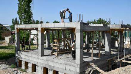 Des ouvriers construisent une bibliothèque, une salle de conférence et une salle de sport pour les femmes, financées par les contributions des travailleurs migrants kirghizes à l'étranger, dans le village de Kyzyl-Jol, le 21 mai 2025 au Kirghizstan
