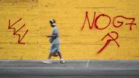 Un graffiti "No G7" sur un magasin protégé par des plaques de bois aggloméré, le 12 juin 2026 à Genève, en Suisse, avant les manifestations en marge du sommet du G7 à Evian, 