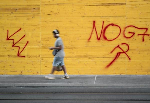 Un graffiti "No G7" sur un magasin protégé par des plaques de bois aggloméré, le 12 juin 2026 à Genève, en Suisse, avant les manifestations en marge du sommet du G7 à Evian, 