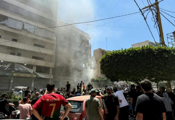 Des habitants sur le site d'une frappe aérienne israélienne qui a ciblé un bâtiment dans la banlieue sud de Beyrouth, le 14 juin 2026 au Liban