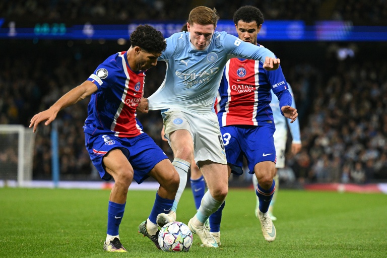 Elliot Anderson (C) de Manchester City aux prises avec Warren Zaire-Emery (D) et Achraf Hakimi (G) lors de la victoire du Paris SG 4-2 sur la pelouse de Manchester City, le 14 octobre 2026