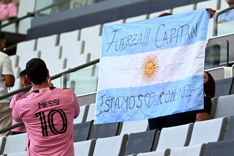 Un supporteur de l'Inter Miami tient un drapeau argentin portant un message de soutien pour Lionel Messi à la suite de la mort de son père, le 8 août 2026 à Miami