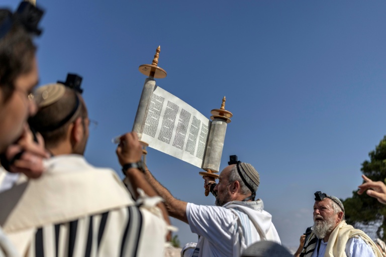 Des colons israéliens prient lors de la réouverture d'une colonie à Ganim, en Cisjordanie occupée, le 13 août 2026