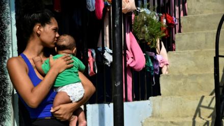 Une femme porte un bébé, à La Fortaleza près de Cucuta, en Colombie, le 9 janvier 2026
