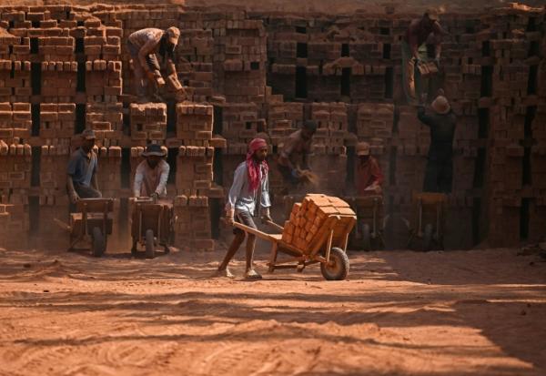 Des travailleurs migrants indiens occupés dans une briqueterie à la périphérie de Srinagar, le 24 août 2026