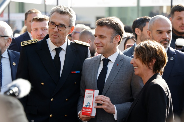 Marc Guillaume, alors préfet de la région Ile-de-France, pose avec le président Emmanuel Macron qui tient un exemplaire du livre sur la Constitution co-écrit par M. Guillaume, le 11 avril 2025 au festival du livre de Paris