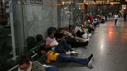 Des voyageurs sont assis ou allongés au sol alors qu'ils se préparent à passer la nuit dans la gare de Cordoue en raison d'une méga-panne électrique affectant l'Espagne et le Portugal le 28 avril 2025