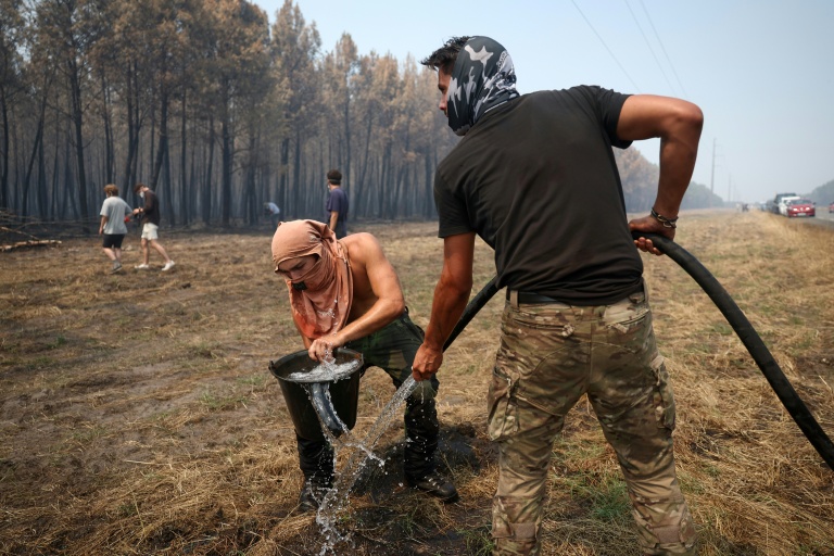 Un volontaire remplit un seau d’eau pour aider à lutter contre l’incendie dans une forêt à Lanton, à l’ouest de Bordeaux, le 29 juillet 2026, lors des feux de forêt dans le département de la Gironde, dans le sud-ouest de la France