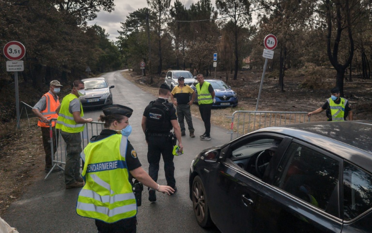 Des gendarmes filtrent des véhicules sur une route menant à la commune de Le Porge, en Gironde, ravagée par un incendie, le 31 juillet 2026 