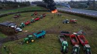 Des agriculteurs allument un feu alors qu'ils participent, avec leurs véhicules, à un blocage d'autoroute, à Poilley, dans l'ouest de la France, le 5 janvier 2026