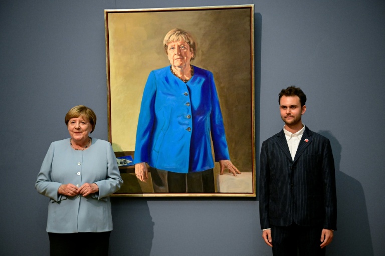 L’ancienne chancelière allemande Angela Merkel (à gauche) et l’artiste franco-allemand Jeremie Queyras (à droite) se tiennent à côté de sa peinture « Portrait de l’ancienne chancelière fédérale Angela Merkel » après son dévoilement au musée Bode à Berlin, le 30 juin 2026.