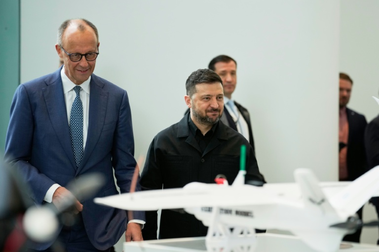  Le chancelier allemand Friedrich Merz (g) et le président ukrainien Volodymyr Zelensky (d) assistent à une présentation de drones issus de la coopération germano-ukrainienne, le 14 avril 2026 à Berlin