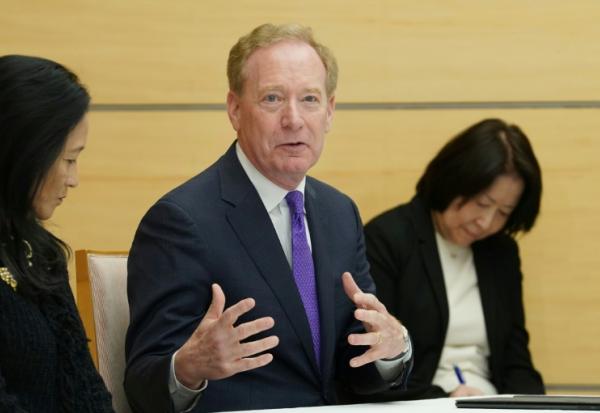 Le vice-président de Microsoft, Brad Smith, au centre, à Tokyo le 3 avril 2026