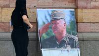Une femme regarde un portrait de l'ancien chef militaire des Serbes de Bosnie, Ratko Mladić, devant la cathédrale orthodoxe de Banja Luka, en Bosnie, le 28 août 2026, au lendemain de sa mort à l'âge de 84 ans dans un hôpital pénitentiaire de La Haye