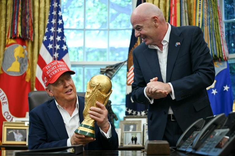 Le président Donald Trump et celui de la Fifa Gianni Infantino, avec le trophée de la Coupe du monde dans le bureau ovale, le 22 août 2025 à Washington, DC 