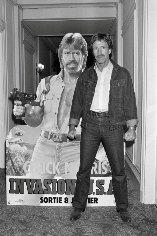 Chuck Norris pose devant l'affiche du film 