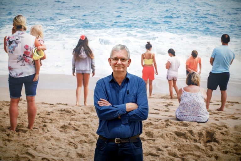 Martin Parr pose devant une de ses photos lors d'une exposition à Londres le 6 mars 2019