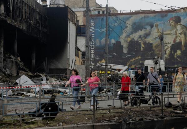 Des habitants passent devant un centre commercial endommagé à la suite des frappes russes à Kiev, le 25 mai 2026