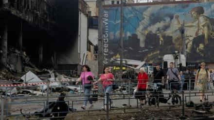 Des habitants passent devant un centre commercial endommagé à la suite des frappes russes à Kiev, le 25 mai 2026