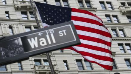 Le drapeau américain flotte derrière un panneau de Wall Street à New York le 22 avril 2026