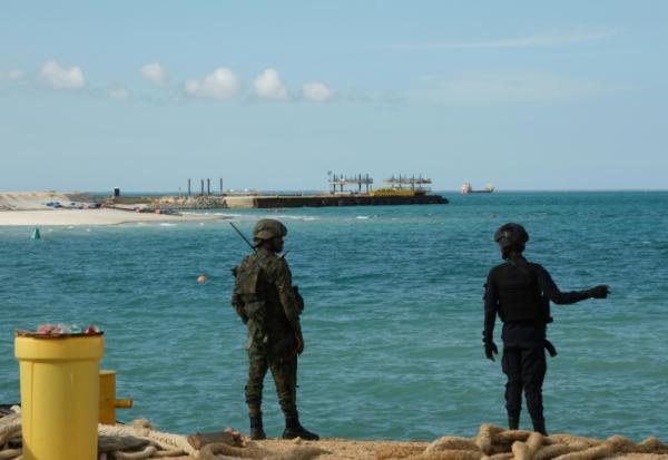 Un policier (d) et un soldat rwandais montent la garde près du projet Total Mozambique LNG à Afungi, dans la province de Cabo Delgado, au Mozambique, le 29 septembre 2022
