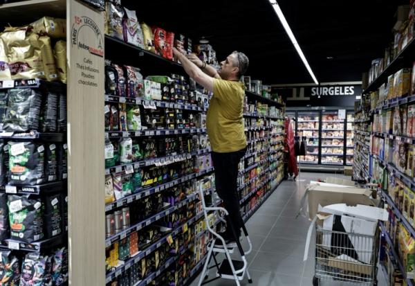 Un employé installe des produits en rayon, le 5 septembre 2025 dans un magasin Intermarché à Paris