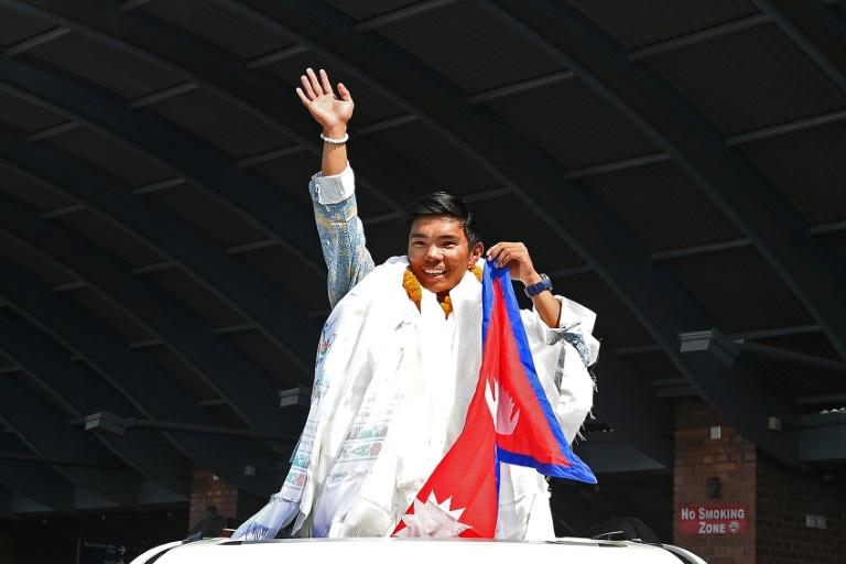 L'alpiniste népalais Nima Rinji Sherpa à son arrivée à l'aéroport de Katmandou, le 14 octobre 2024, après avoir battu le record du plus jeune alpiniste à avoir gravi les 14 sommets mondiaux de plus de 8 000 mètres