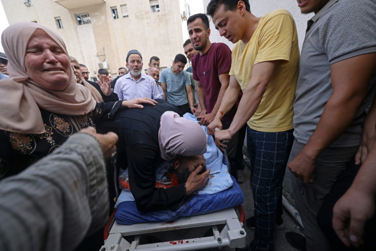 Une femme embrasse un proche, tué lors de violences, devant un hôpital de Naplouse, en Cisjordanie occupée, le 24 juillet 2026