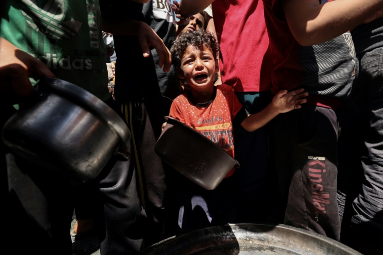 Lors d'une distribution de nourriture dans le camp de Nousseirat, dans le centre de la bande de Gaza, le 23 mai 2025