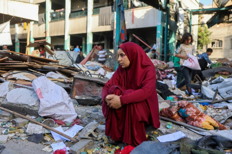 Une femme est assise au milieu des décombres après le bombardement d'une école à Gaza-ville, le 26 mai 2025