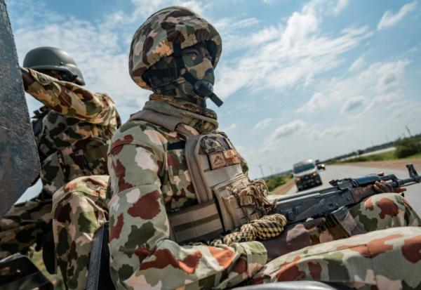 Un soldat nigérian à l'arrière d'un véhicule d'escorte militaire sur l'autoroute reliant Maiduguri à Damaturu, au Nigeria, le 31 juillet 2026.